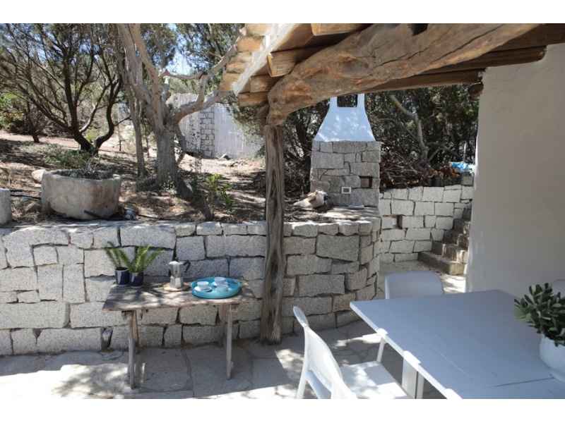 Villa Maria Mercedes - Casa vacanze sul mare a Villasimius in Sardegna - spazi esterni con barbecue in pietra e tavolini.