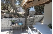 Villa Maria Mercedes - Casa vacanze sul mare a Villasimius in Sardegna - spazi esterni con barbecue in pietra e tavolini.