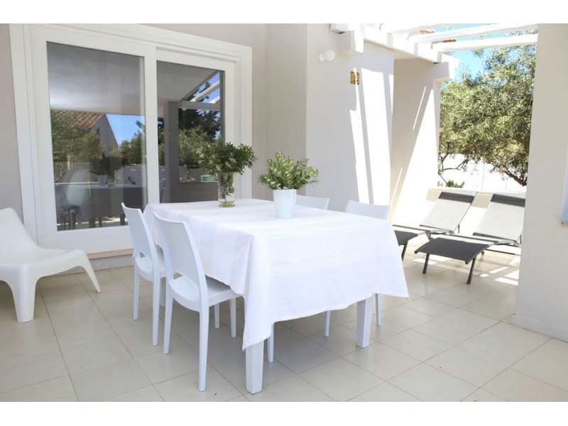 Villa Agave - Casa vacanze sul mare a Villasimius in Sardegna - patio esterno moderno e accogliente con tavoli e sedie.