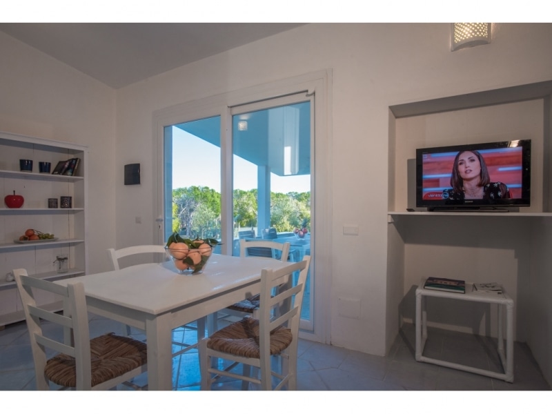 Villa Climene - Casa vacanze sul mare a Villasimius in Sardegna - Sala da pranzo con ampia vetrata che si affacia sul patio arredato.