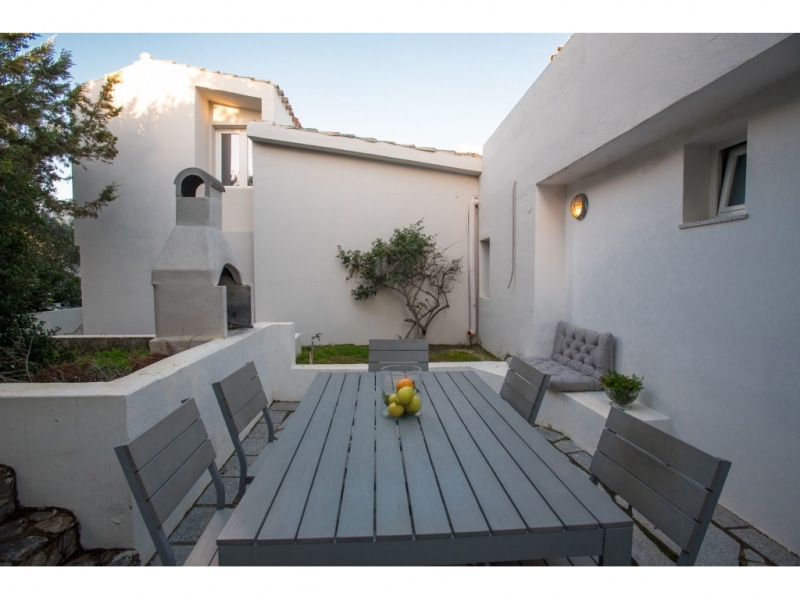 Villa Criside - Casa vacanze sul mare a Villasimius in Sardegna - cortile esterno posteriore con tavolino e sedie.